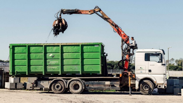Camião com contentor “polibenne” e grifo em operação na gestão de Resíduos Industriais