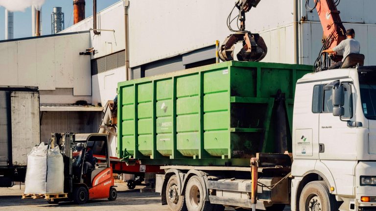 Camião com contentor “polibenne” e grifo e empilhador em operação na gestão de Resíduos Industriais